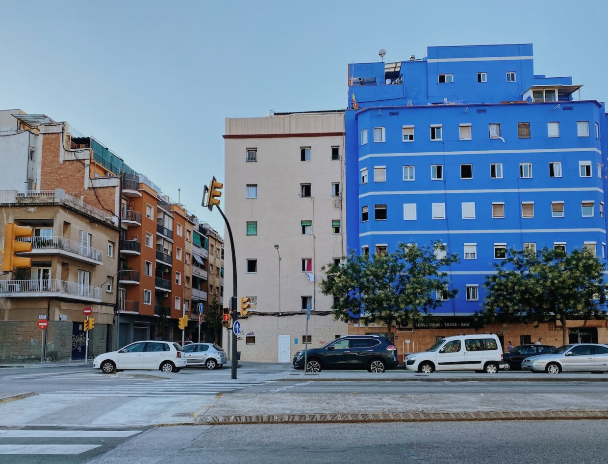 cars parked in front of blue concrete building during daytime